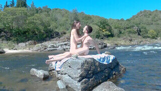 Kúrás a sziklákon a folyóparton egy amatőr párral